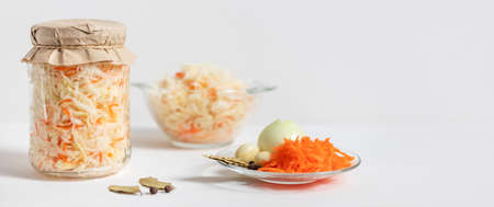 Sauerkraut on a white background. Banner. Cabbage salad with carrots. Fermented food. Space for...