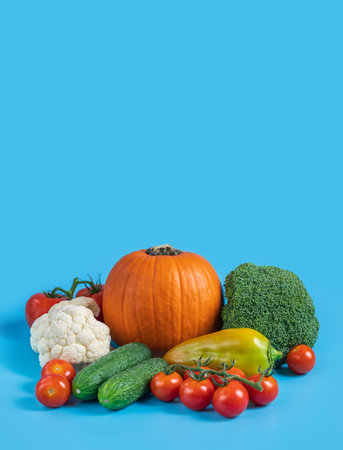 Vegetable mix on a blue background. Autumn harvest. Organic healthy food. Vertical orientation. Space for text.の写真素材
