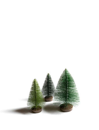 Small Christmas trees isolated on white background. Vertical orientation. Copy space