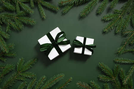 Christmas gifts and fir branches on a dark green background. Happy new year. Greeting card. Top view, flat lay.の写真素材