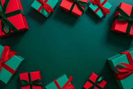 Gifts frame on a green background. Christmas or festive decorations. Green and red gift boxes. Copy space, template. Top view, flat lay.の写真素材