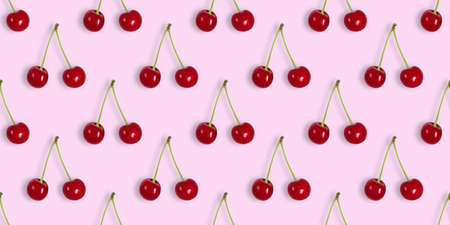 Seamless pattern with cherries on a pink background. Cherry seamless textures for design. Berry summer background. Top view, flat lay. Banner.の写真素材