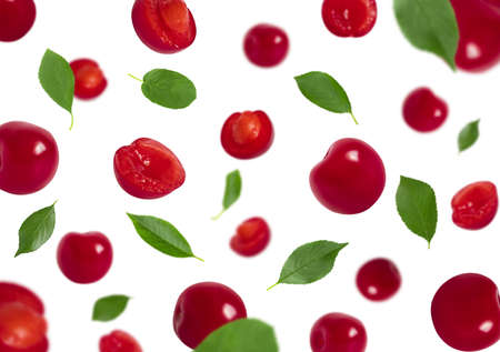 Set of falling cherries with green leaves isolated on a white background. Red berries flying in the...