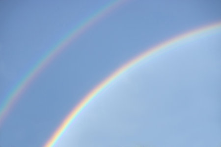 Double rainbow in a clear blue sky on a sunny day. Natural rainbow after the rain.の写真素材