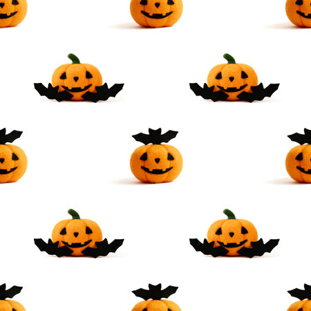 Seamless pattern with Halloween wool toy pumpkin and bats on a white background. Jack o lantern head background.の写真素材