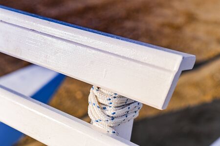 White wooden bench on the beach. Natural lighting street photo. Free space for text