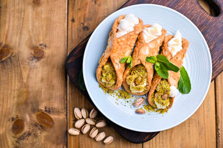 Cannoli Sicily. Traditional Italian sweet with ricotta and various fillings. Food on a wooden...