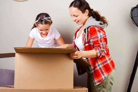 July 13, 2020 Italy, Bologna. Unpacking the Amazon parcel. Mom and daughter open the box and joyfully get their purchases from the online store. Delivery and service concept. Online shopping. Europeanの写真素材