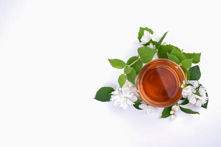 Jasmine tea. A traditional drink in China for health and vitality. Oriental medicine. Fresh jasmine flowers on white background and a cup of tea. Free space for text. Photos of light colorsの写真素材