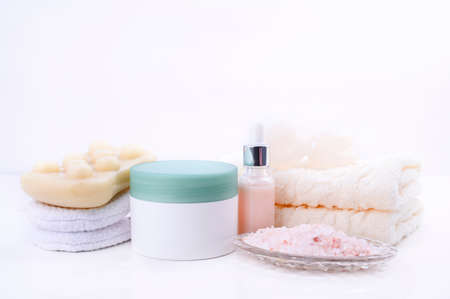 Spa relax and bath concept, sea salt, soap, with cosmetics and towels on a white background. A soft...