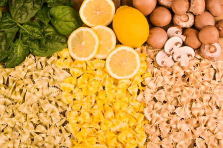 Multi-colored pasta with spinach, mushrooms and lemon. Typical cuisine of southern Italy. Dry Butterfly pasta with different flavors on a wooden background. High quality photoの写真素材