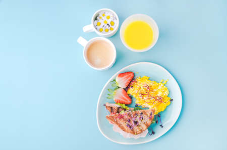 Coarse bread toast with ham, salad and scramble, sprinkled with sprouted seeds. Super food, aromatic coffee and a glass of orange juice. Delicious healthy breakfast on a bright background.の写真素材