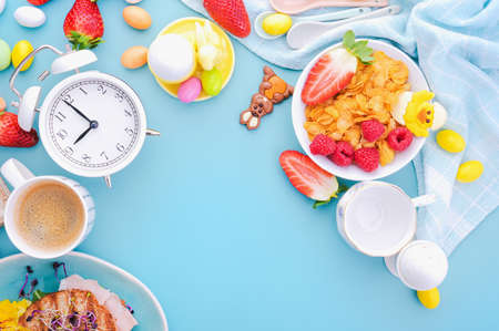 Easter breakfast on a bright background. Epresso, juice and muesli with berries, chocolate eggs of...
