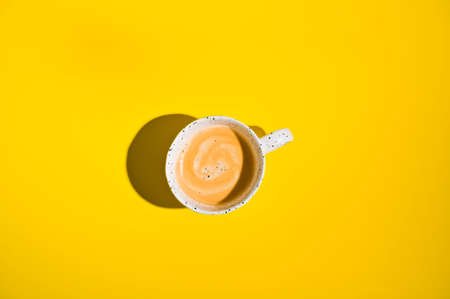 Cup Hot Beverage Coffee Scattered on Yellow Background Top View Flat Lay. Photo with hard light. A lot of free space for textの写真素材