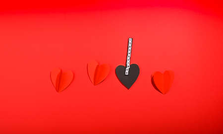 Coronavirus. COVID 2019 A red background, with paper hearts, where black shows an epidemic, the text is the name of the virus in detail. World pandemic concept. Copy spaceの写真素材