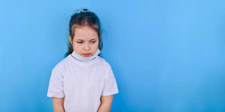 Baby in coronavirus. World pandemic concept COVID 19. Little girl in a protective medical mask closes her eyes with her hands. The emotions of the child in the photo close-up. Copy space . Banner.の写真素材