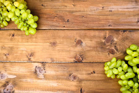 White grapes on a wooden background. Juicy and ripe bunches of grapes. Top view. Free space for text. Copy space.の写真素材