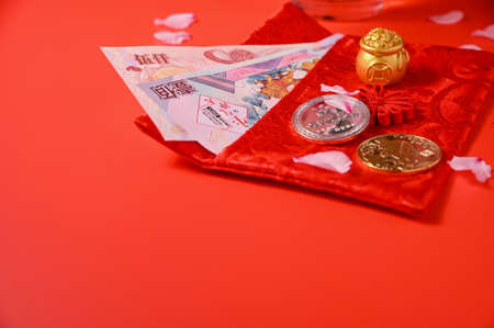 Chinese New Year 2021 is year of the ox, Chinese characters . Chinese new year ornament. gold ingot and golden abacus. Blooming almond petal and coins on a red background. Copy spaceの写真素材