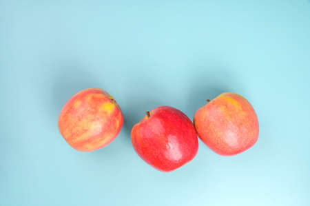 Beautiful red rustic apples on a blue background. Free space for text. High quality photoの写真素材