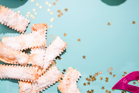 Carnival food TYPICAL. Sfrappole or chiachiere or angel wings on a blue background. Traditional sweet crisp pastry deep-fried and sprinkled with powdered sugar. Copy spaceの写真素材