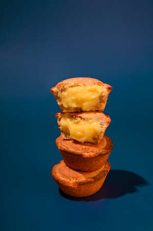 Pasticciotti . Typical pastries from the south of italy, the Apulia region. Buns with cream on a blue background. Hard light,の写真素材
