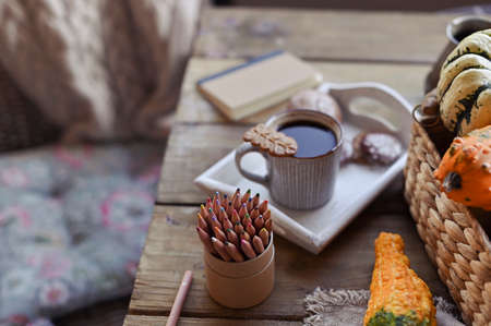 Autumn, pumpkins, hot steaming cup of coffee on a wooden table background. Seasonal, morning coffee, sunday relaxing and still life concept. Plans for the dayの写真素材