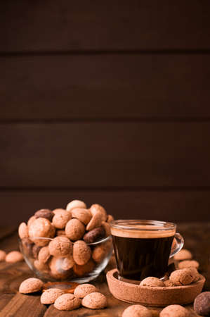 Small mug Espresso coffee and Traditional sweets, cookies pepernoten on a wooden table. Copy space. Dutch holiday Sinterklaas. High quality photo.の写真素材