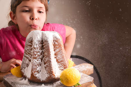 Beautiful Little girl blowing icing sugar off the Soft star-shaped pasta. Traditional Italian...