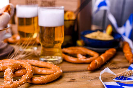 Fresh beer with foam on a wooden background. Oktoberfest German Pretzels.の写真素材