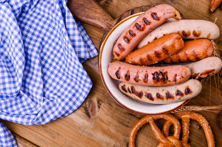 Traditional bavarian grilled sausages with mustard for oktoberfest celebration. Wooden background and national food. Top view. Copy space.の写真素材