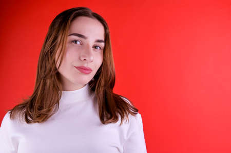 Young girl on a red background. Free space for textの写真素材