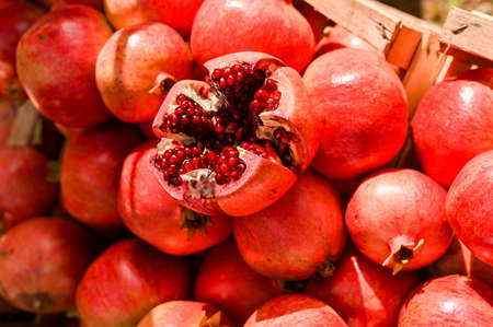 Ripe pomegranates in a basket at the market. Seasonal fruits.の写真素材