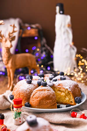 Christmas cake with berries and icing sugar on a wooden background. piece of cake. Traditional...