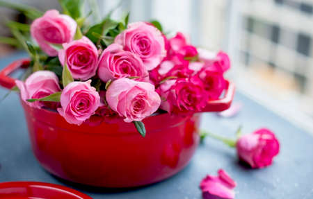 Bouquet of roses for mom, gift concept for women and mothers day. Creative surprise flowers in a red pan. Free space for text, postcard. Copy space.の写真素材