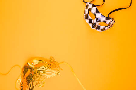 Carnival mask on a yellow background. Decor for a traditional Italian holiday. Copy space. Flat lay.の写真素材