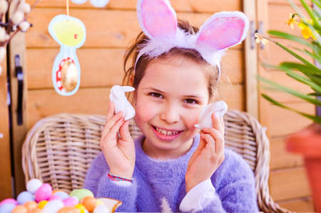 Easter. Little girl with colored eggs and chocolate colored eggs. Happy Easter holiday at home....