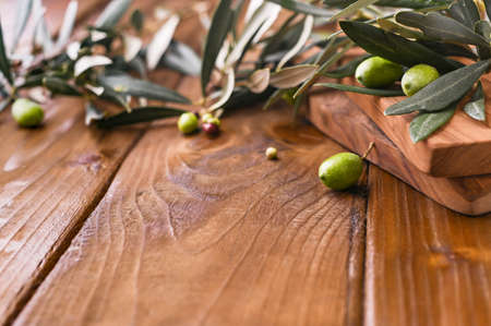 Olive branches and berries olives close-up on a wooden background. Copy space.の写真素材