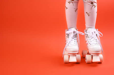 Roller skates on the legs of a urenburg. Retro rollers on a bright background. The concept of childrens outdoor sports. Free space for text.の写真素材