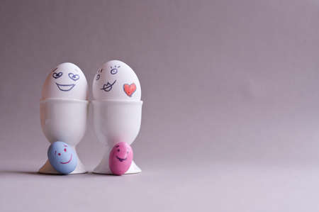 Eggs with a face. Mom, dad and a lot of little colored kids eggs. The Creative idea for decorating Easter Sunday. Copy space . Minimalismの写真素材