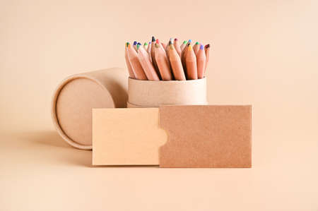 Business card mockup , eco kraft paper and a set of colored pencils on a beige background. Eco friendly stationery concept. Recyclable. High quality photo. Copy spaceの写真素材