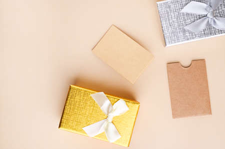 Business card mockup, eco kraft paper on a beige background and gift box for the holiday. Eco friendly stationery concept. Recyclable. High quality photo. Copy space. Verticalの写真素材