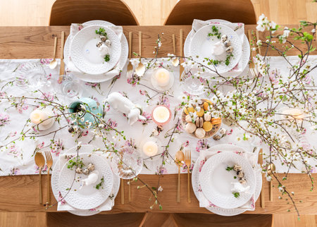 Spring Easter decor. Easter table setting. Flowers and dishes and candles for a festive dinner. High...