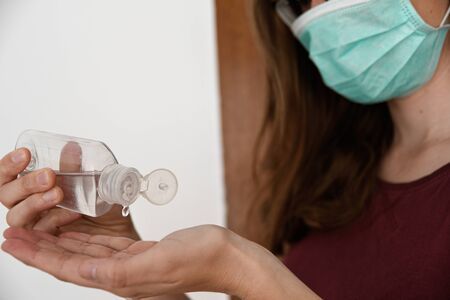 COVID-19 Close up on woman hands using wash hand sanitizer gel dispenser, against Novel coronavirus...