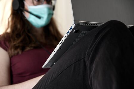 Woman in quarantine for Coronavirus wearing protective mask and smart workingの写真素材