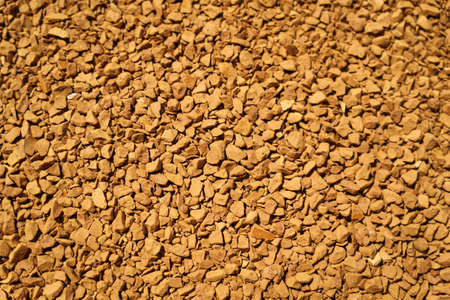 Background of instant coffee granules at life-size magnification