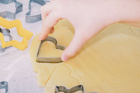 Girl bakes Christmas gingerbread cookies, cooking in the kitchen.の写真素材