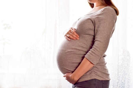 Pregnant woman with big belly in profile. Maternity prenatal care and woman pregnancy concept. Young...