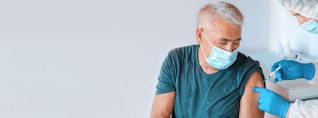 Doctor Vaccinating Senior Man In Clinic. Elderly People Vaccination. Doctor Giving   Vaccine...