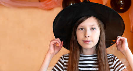 Portrait of adorable Teen Girl wearing Halloween hat, dancing and smiling. Halloween home family...