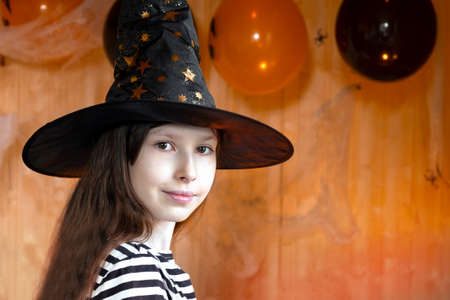 Portrait of adorable Teen Girl wearing Halloween hat, dancing and smiling. Halloween home family...